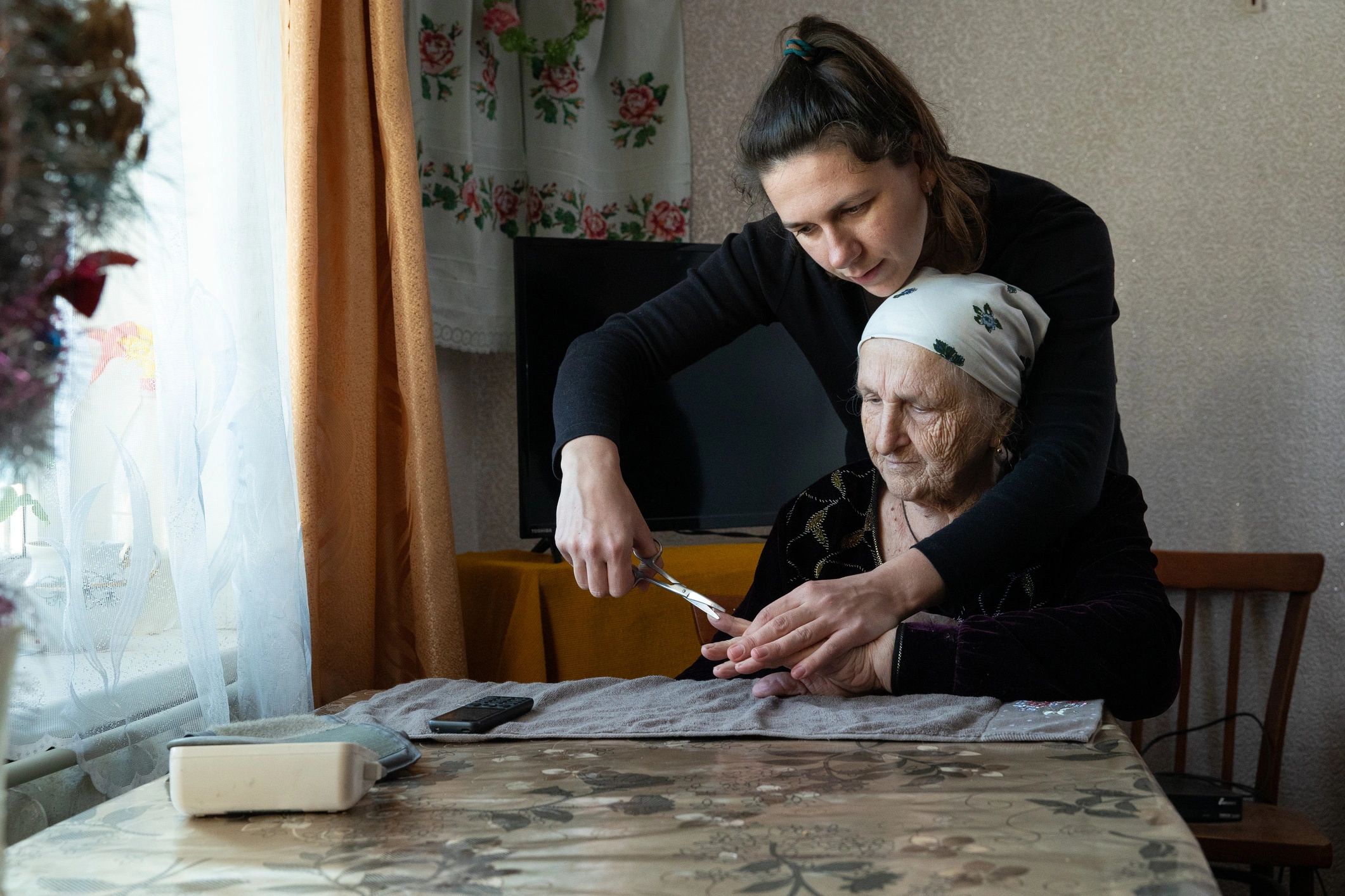 Woman helping her grandmother at home